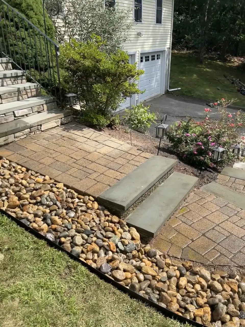 River rock border along a curved paver walk